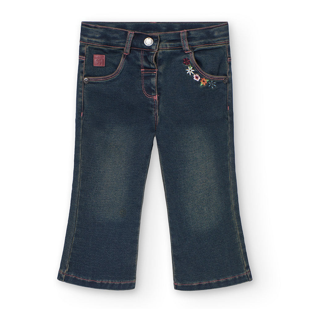 
Denim-Hose aus der Kinderbekleidungslinie Boboli mit ausgestelltem Modell und aufgestickten Blum...